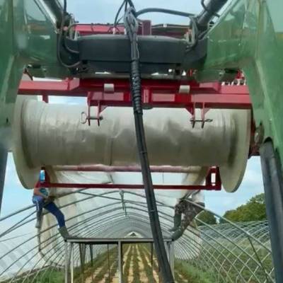 Wiesel 2400 attached to front loader when winding greenhouse film